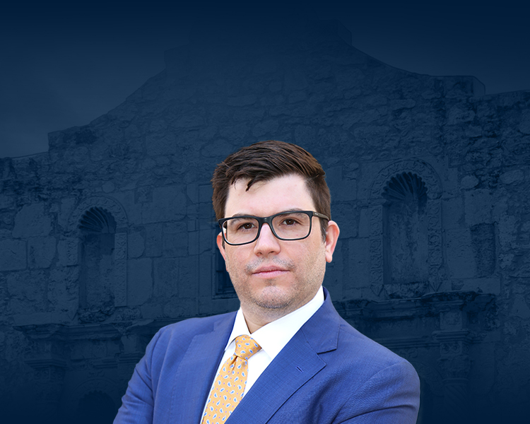 Daniel De La Garza with a background featuring a photograph of an old building with a blue filter, next to him the De La Garza Criminal Defense, PLLC logo.